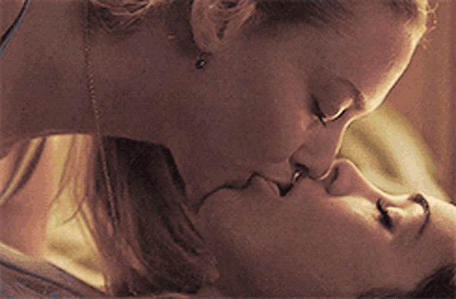 two women are kissing each other with their tongues hanging out
