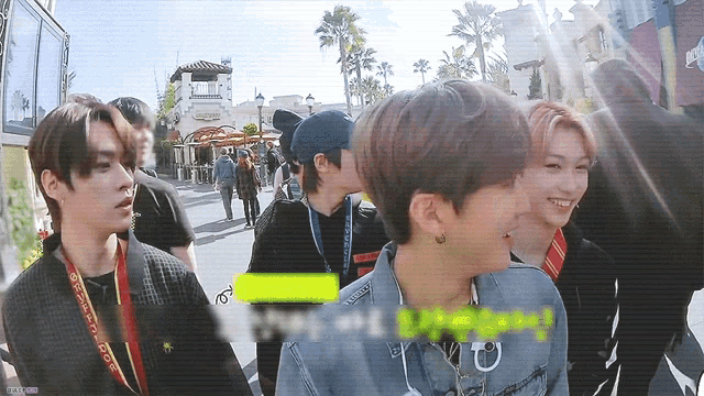 a group of young men are walking down a street and one of them is wearing a lanyard that says universal