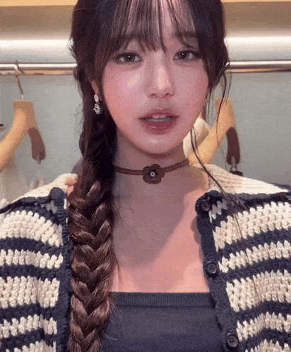 a woman wearing a choker and a striped sweater