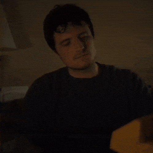 a man is sitting at a table eating a banana