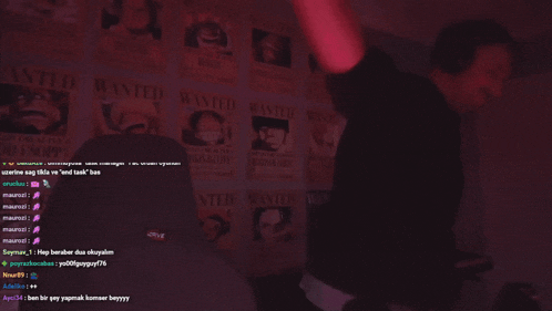 a man wearing headphones is dancing in front of a wall with wanted posters
