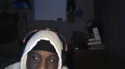 a man wearing a white hoodie is smiling and waving his hand