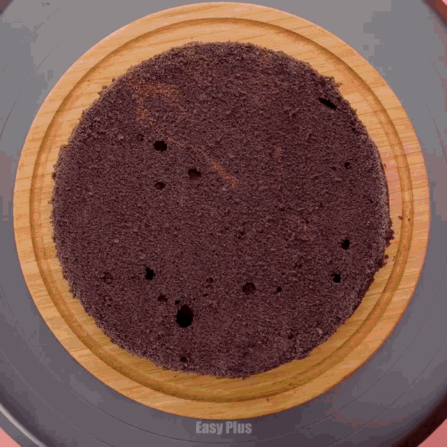 a cake on a wooden plate with easy plus written on the bottom
