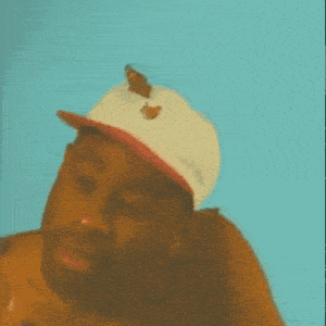a shirtless man wearing a hat with butterflies on it is surrounded by butterflies on his chest .