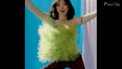 a woman in a green dress is dancing with her arms outstretched in a room .