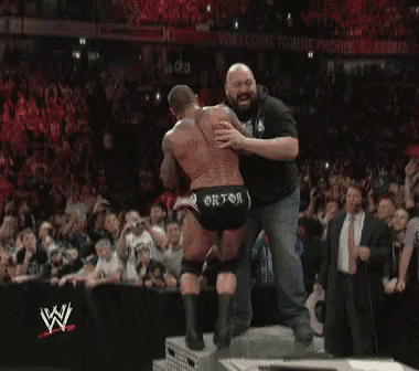 a blurred image of a wrestling match with the w logo on the bottom