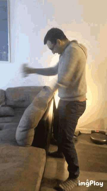 a man is cleaning a couch with a gif that says imgplay in the lower right corner