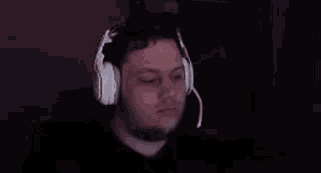 a blurry picture of a person wearing headphones and covering their face .
