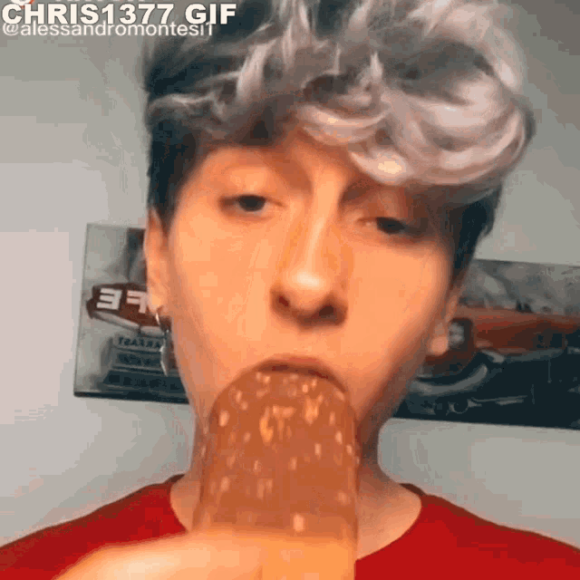 a young man is eating a chocolate ice cream bar with his mouth open .