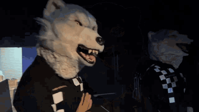 a person wearing a wolf mask is sticking out their tongue and licking it .