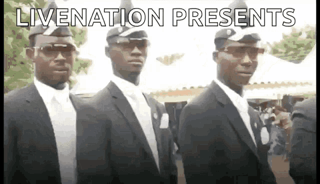a group of men in black suits and hats are standing next to each other .