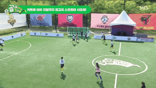 a group of soccer players are playing on a field with a sign that says super