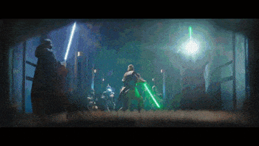 a group of men are fighting with lightsabers in a dark room .