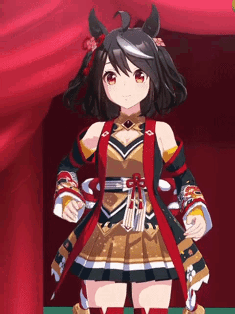 a girl in a cheerleader outfit is standing in front of a red curtain and smiling