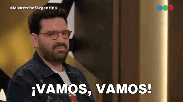 a man with glasses says " vamos vamos " in spanish