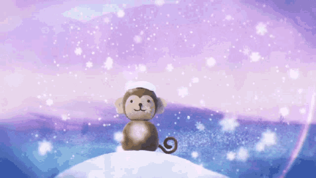 a stuffed monkey is sitting on a snowy hill