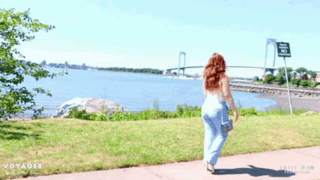 a woman walking in front of a sign that says no