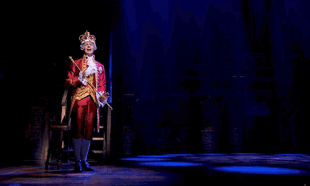 a man in a crown is holding a cane