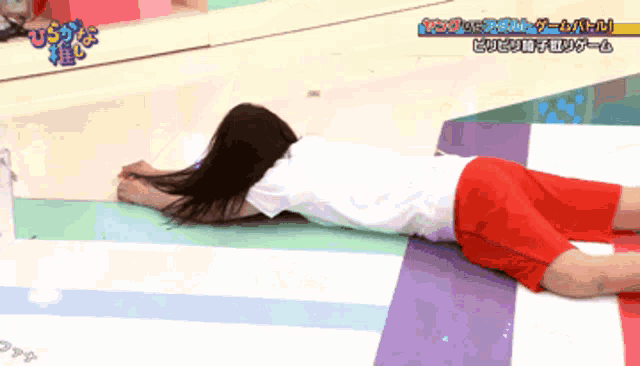 a woman in red shorts is laying on the floor in front of a sign that says ' tokyo ' on it