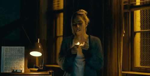 a woman is lighting a match in front of a sheet of music