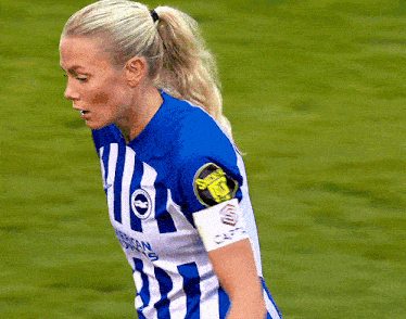 a female soccer player wearing a blue and white striped jersey with the number 1 on the front