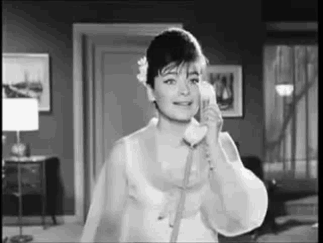a black and white photo of a woman talking on a phone .