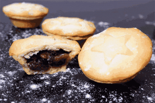 three mince pies with powdered sugar on them