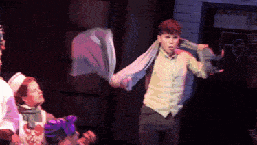 a man with a scarf around his neck is on stage