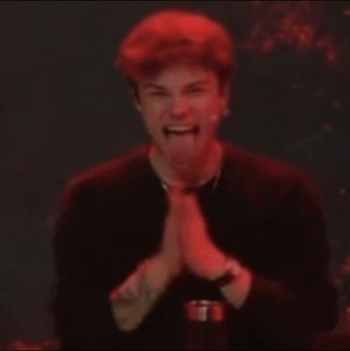 a man in a black shirt is making a funny face