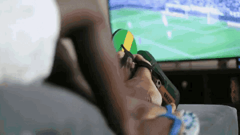 a person is watching a soccer game on a tv and their flip flops say nescafe on them
