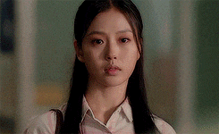 a close up of a woman 's face with long hair wearing a pink shirt .