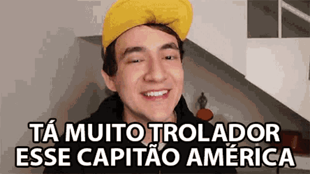 a man wearing a yellow hat is smiling with the words ta muito trolador esse capitao america below him .