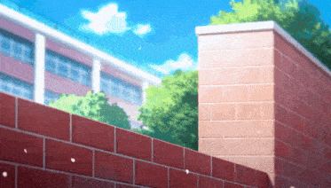 a brick wall with a building in the background and trees in the foreground