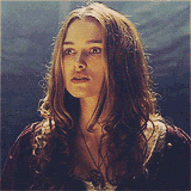 a woman with long hair is wearing a necklace and a red shirt