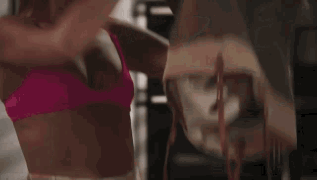 a woman in a pink bikini is holding a piece of wood