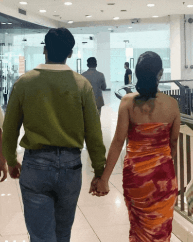 a man and a woman holding hands in a store