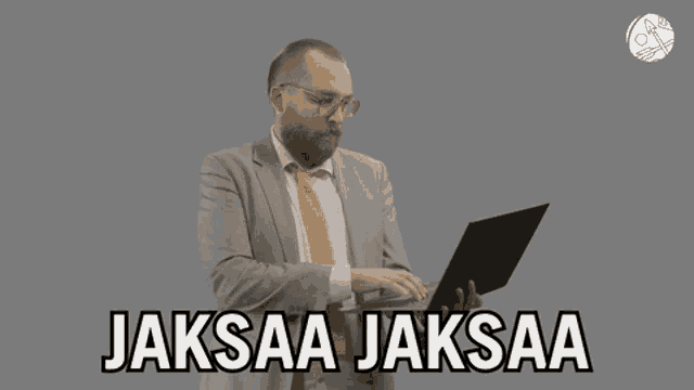 a man in a suit and tie is typing on a laptop and the words " jaksaa jaksaa " are above him
