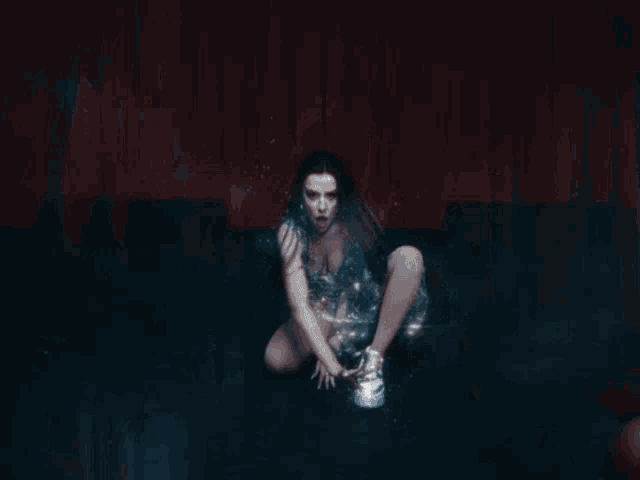 a woman in a sequined dress is kneeling down