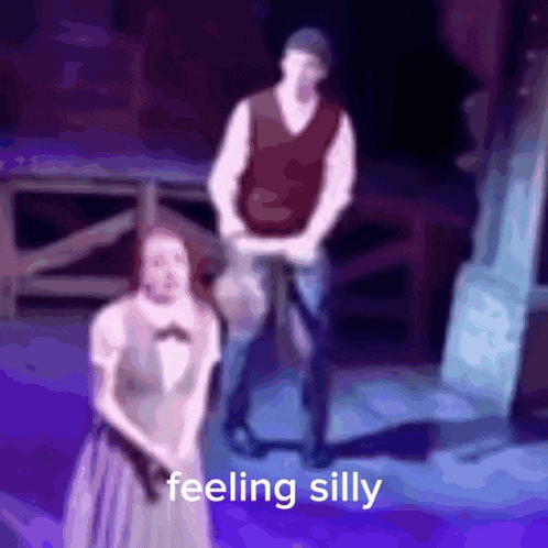 a blurry picture of a man and a woman on a stage with the words feeling silly below them .