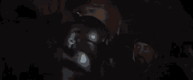 a man in a helmet is sitting in a car with a red light coming out of the back .