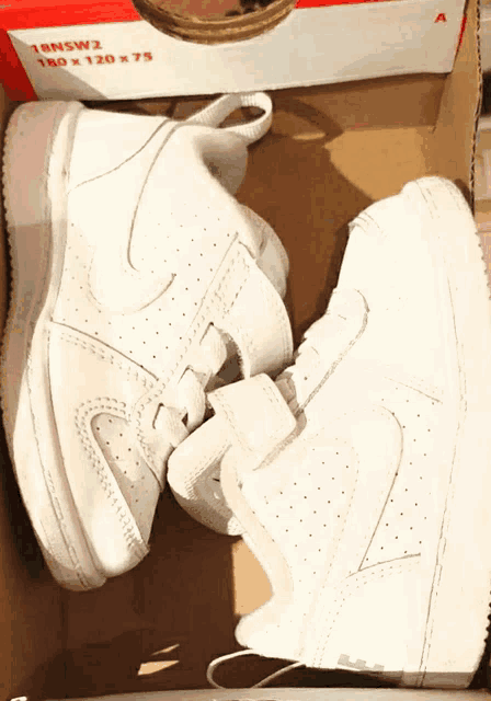 a pair of white nike shoes are in a box