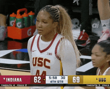 a female basketball player for the usc team stands on the court