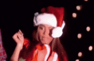 a woman is wearing a santa hat and a christmas sweater .