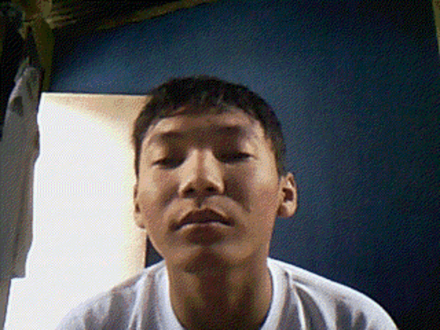 a young man in a white shirt is looking at the camera