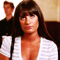 a woman wearing a striped shirt with a plunging neckline is looking at the camera .