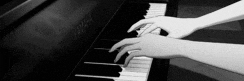 a person is playing a piano with their hands on the keys .