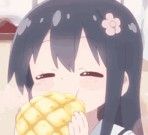 a girl with a flower in her hair is eating a yellow item