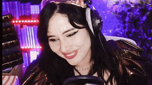 a woman wearing headphones and a crown is smiling while playing a video game