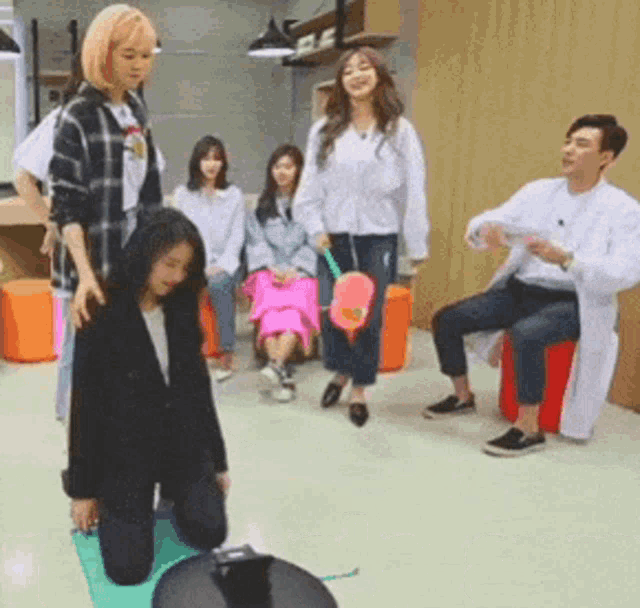 a group of people are playing a game while a man in a lab coat watches