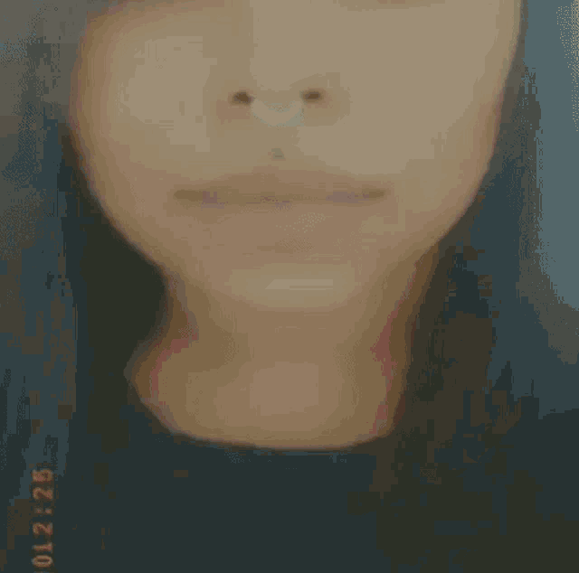 a close up of a woman 's face with a nose ring on her nose .